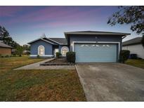 Newly painted blue house with light blue garage door and landscaped yard at 1330 Monte Lake Dr, Valrico, FL 33596