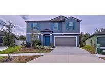 Two-story house with gray siding, teal door, and two-car garage at 13455 Jamaica Plank Loop, Riverview, FL 33579