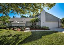 Single story home with gray siding, landscaping, and a two-car garage at 3147 Hyde Park Dr, Clearwater, FL 33761