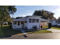 White single-wide mobile home with carport and small patio at 37402 Hammond Dr, Zephyrhills, FL 33541