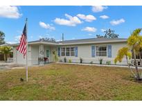 Charming single story home with a manicured lawn and American flag at 5871 49Th N Ave, Kenneth City, FL 33709