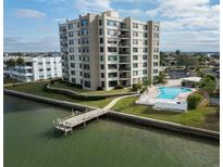 Drone view of waterfront condo building with pool and private pier at 750 Island Way # 401, Clearwater Beach, FL 33767