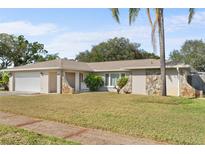 Ranch-style home with a large yard and attached garage at 13561 105Th Ave, Largo, FL 33774