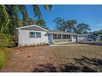 Newly renovated single story home with white brick exterior and landscaped yard at 2318 Granada W Cir, St Petersburg, FL 33712