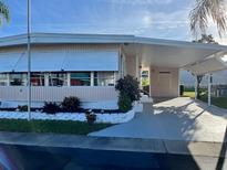 Mobile home exterior features carport and well-maintained landscaping at 34091 Alamanda N Dr, Pinellas Park, FL 33781