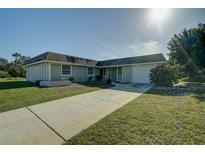 Single-story house with a driveway, lawn, and attached garage at 4173 Driver Ln, Port Charlotte, FL 33981