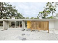 Mid-century modern home with a yellow door and geometric patterned walkway at 5027 Sunrise S Dr, St Petersburg, FL 33705