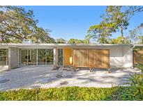 Mid-century modern home with a yellow door and a unique hexagonal patio at 5027 Sunrise S Dr, St Petersburg, FL 33705