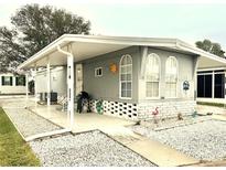 Mobile home exterior features covered porch and landscaped yard at 9790 66Th N St # 194, Pinellas Park, FL 33782