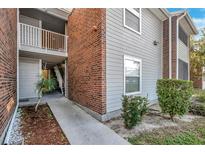 Exterior view showing building with brick and siding, walkway, and landscaping at 1400 Gandy N Blvd # 1407, St Petersburg, FL 33702