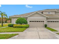 Tan two-story home with attached garage and manicured landscaping at 16130 Craigend Pl, Odessa, FL 33556