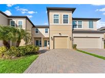 Two-story townhome with a paved driveway and landscaping at 29913 Southwell Ln, Wesley Chapel, FL 33543