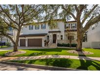 Two-story house with a three-car garage and manicured lawn at 5020 W Dickens Ave, Tampa, FL 33629