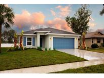 New single-story home with a blue garage door and landscaped lawn at 528 Rose Apple Cir, Port Charlotte, FL 33954