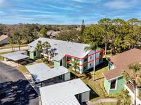 Aerial view of condo community, highlighting a charming green and white building near a lake at 2561 Royal Pines Cir # 14H, Clearwater, FL 33763
