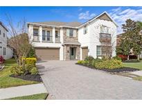 Two-story home with stone accents and a three-car garage at 28475 Marsciano Ln, Wesley Chapel, FL 33543