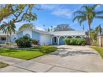 Light blue house with a large front yard, driveway, and mature trees at 5630 Venetian Ne Blvd, St Petersburg, FL 33703