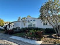 Single-wide manufactured home with landscaped yard and covered entry at 8512 Fantasia Park Way, Riverview, FL 33578