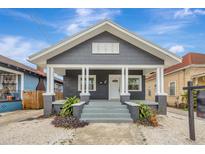 Gray house with white trim, front porch, and landscaped yard at 915 E 20Th Ave, Tampa, FL 33605