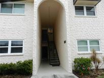 Exterior view of building entrance with stairs and arched entryway at 214 Elmwood Cir # 214, Seminole, FL 33777