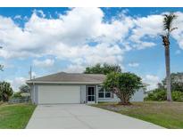Single-story home with attached garage and landscaped yard at 2369 N Biscayne Dr, North Port, FL 34291