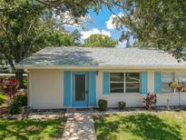 Tan house with blue shutters, walkway, and landscaping at 402 Dorchester Pl # 28, Sun City Center, FL 33573