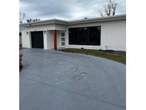 Modern, single story home with attached garage and a long driveway at 445 80Th Way, St Pete Beach, FL 33706