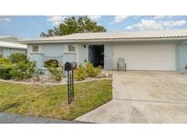 Light blue house with a white roof, landscaped yard, and a two-car garage at 804 67Th W St, Bradenton, FL 34209