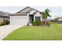 One-story home with gray siding, landscaping, and a two-car garage at 8203 Abalone Loop, Parrish, FL 34219