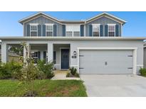 Two-story house with gray siding, blue shutters, and a two-car garage at 8368 Greenway Ave, Wesley Chapel, FL 33544