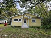 Cute yellow house with a small front yard and mature trees at 908 N Gordon St, Plant City, FL 33563