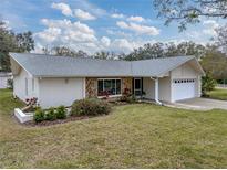 Ranch-style home with stone accents and a well-maintained lawn at 1559 Glengarry Dr, Palm Harbor, FL 34684