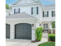 Two-story townhome with gray doors, two-car garage, and manicured landscaping at 208 S Lincoln Ave, Tampa, FL 33609
