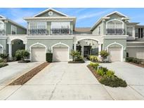 Attractive three-unit townhome building with attached garages and landscaping at 2135 Park Crescent Dr, Land O Lakes, FL 34639