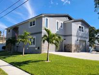 Two-story house with gray exterior, three-car garage, and palm trees at 1600 Pennsylvania Ne Ave, St Petersburg, FL 33703