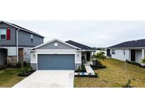 Single-story home with gray siding, two-car garage, and landscaped lawn at 2667 89Th Street E Cir, Palmetto, FL 34221