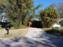 House exterior with green and orange siding, a paved driveway, and mature bamboo at 5209 10Th S Ave, Gulfport, FL 33707