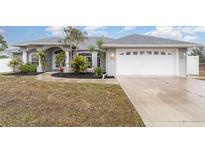 Gray house with a white garage door and landscaping at 5366 Hader Rd, North Port, FL 34288