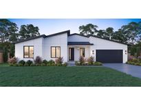 Modern house exterior with white walls, dark garage door, and landscaping at 6708 Burlington Ave, St Petersburg, FL 33710