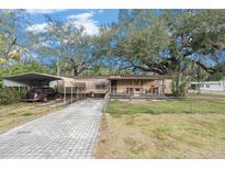 Mobile home with carport, paved driveway, and large shade trees at 7401 Mount Vernon Rd, Tampa, FL 33625