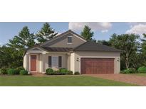 One-story home with a brown roof, red door and wooden garage door at 31819 Cardinal Yard Dr, San Antonio, FL 33576