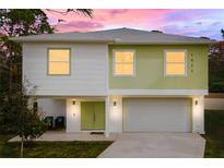 Two-story house with light green and white exterior, two-car garage, and landscaping at 4829 Jenny Way, New Port Richey, FL 34652