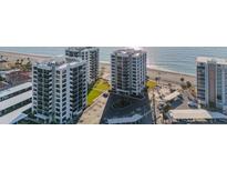 Aerial view of two beachfront high-rise buildings with parking and ocean views at 629 Alhambra Rd # 604, Venice, FL 34285