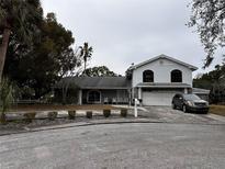 Two-story house with a large driveway and mature landscaping at 8814 Mill Creek Ln, Hudson, FL 34667