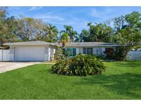 Ranch style home with attached garage and well-manicured lawn at 11453 Imperial Grove E Dr, Largo, FL 33774