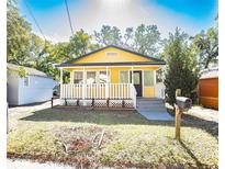 Charming yellow house with white porch and landscaped lawn at 1913 E Wilder Ave, Tampa, FL 33610