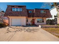 Two-story house with attached garage, and a red door at 3118 S Maritana Dr, St Pete Beach, FL 33706