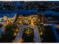 Luxury waterfront home with a circular driveway and lush landscaping at 335 Bath Club S Blvd, North Redington Beach, FL 33708