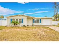 Ranch style home with white brick facade, blue shutters, and a well-maintained lawn at 5810 Town N Country Blvd, Tampa, FL 33615