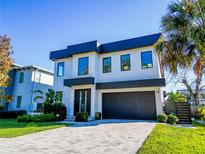 Modern two-story home with a dark gray roof and attached garage at 818 W Adalee St, Tampa, FL 33603